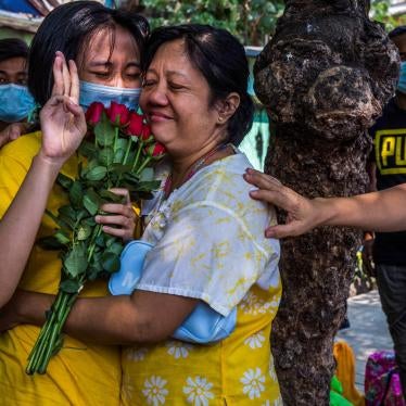 A woman holds up a three finger salute