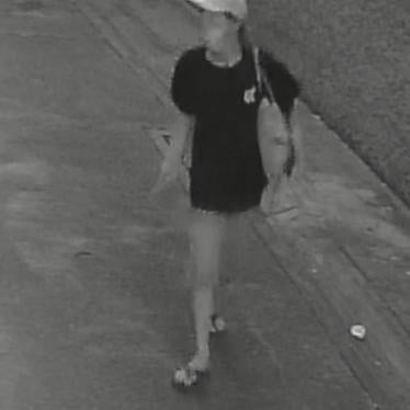 Photo captured on a security camera of the alleged assailant, a woman wearing a mask and a black t-shirt.