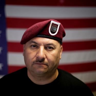 A man poses for a photo in front of an American flag