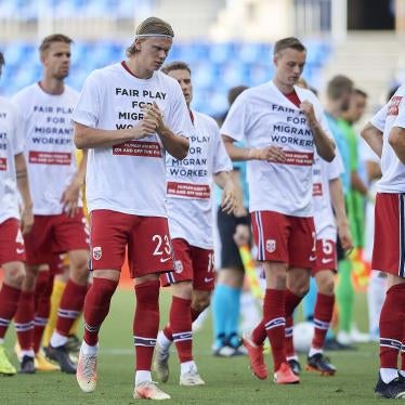 Members of a football team wear t-shirts calling for human rights for migrant workers 