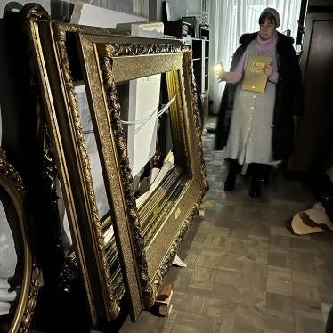 A woman shines a flashlight on a stack of empty picture frames
