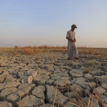 A fisherman walks across a dried patch of land in the marshes of southern Iraq in Dhi Qar province, September 2, 2022. Iraq's marshlands are rapidly receding due to drought, domestic water mismanagement, and diversion from neighboring countries.