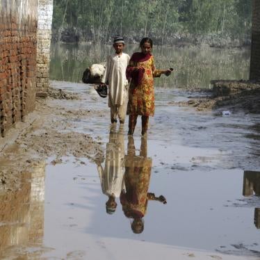 Two children wade through mud near their flood-hit home in Charsadda, Pakistan.