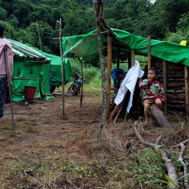 Hla Win walks with crutches near her son at a displacement camp near Pekon township, Myanmar, July 29, 2023. 