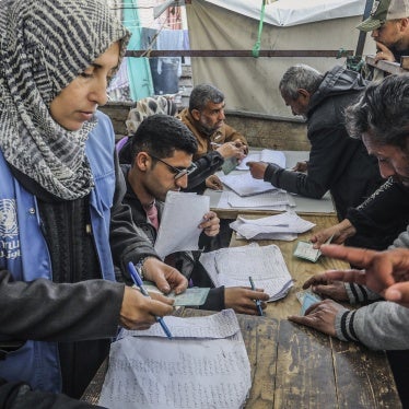 Palestinians receive humanitarian aid from the United Nations Relief 