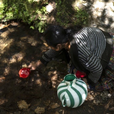 A woman collects water to drink from a well in Santa María Chiquimula municipality, Totonicapán department, Guatemala, March 11, 2025.