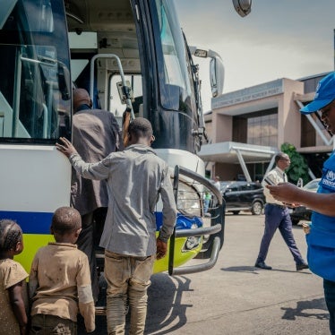 Displaced people board a bus after undergoing checks at the border between the Democratic Republic of Congo and Rwanda