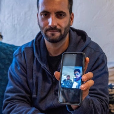 Afghani evacuee Israr, 26, shows photos on his phone of himself working in Afghanistan as a translator with military forces at his new apartment in Charlestown, Massachusetts, February 21, 2022.