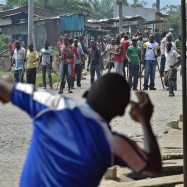 A protestor throwing rocks at members of Imbonerakure.