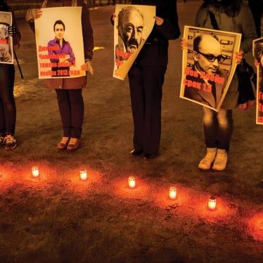 People hold posters depicting victims of homophobic violence at a public event in St. Petersburg.