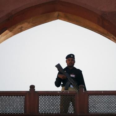 A police officer is framed by the architecture of Lahore's Badshahi Mosque while standing guard during a prayer session on Eid al-Adha November 7, 2011. © 2011 Mohsin Raza/Reuters 