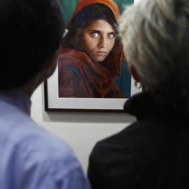 Visitors look at the "Afghan Girl" photo during U.S. photographer Steve McCurry's exhibition at the Asian Civilisation Museum in Singapore June 26, 2009.
