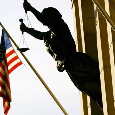 The American flag flies next to a statue of the scales of justice at United States Court House, February 6, 2002.