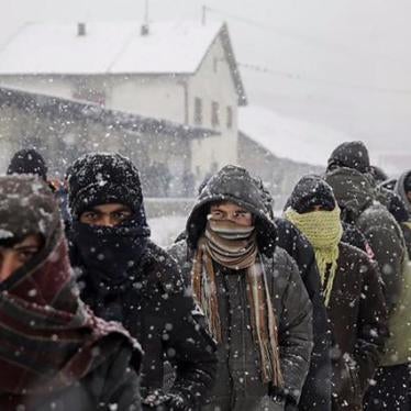 Migrants wait in line to receive free food during a snowfall outside a derelict customs warehouse in Belgrade, Serbia January 9, 2017.