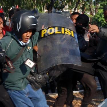 A police officer kicks photographer Ikshan Arham of the Rakyat Sulsel newspaper during a  student protest at Makassar State University on November 13, 2014. Police allegedly assaulted 10 journalists that day, but no officers have been prosecuted for those