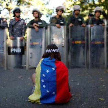 A girl wears a Venezuelan flag as Venezuelan security forces block access to opposition supporters and mourners of rogue ex-policeman Oscar Perez to the main morgue of the city, in Caracas, Venezuela January 20, 2018. 