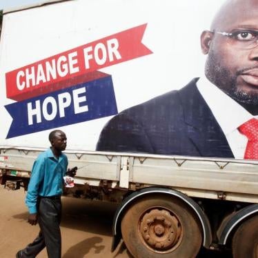 A supporter walks by an image of George Weah, President of Liberia, in Monrovia, Liberia, December 27, 2017. © 2017 Reuters