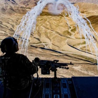 A US army crew chief flying onboard a Chinook helicopter observes a test of flares during a training flight in Afghanistan, March 14, 2018.