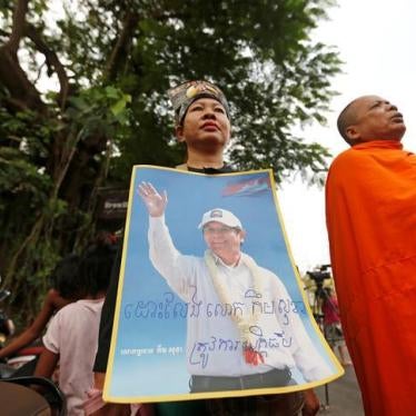 Supporters of Kem Sokha, former opposition leader and ex-president of the now-dissolved Cambodia National Rescue Party (CNRP), hold up a poster near the Appeal Court in Phnom Penh, Cambodia, March 27, 2018. 