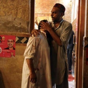 A political party worker comforts another after a suicide attack during an election campaign meeting in Peshawar, Pakistan, July 10, 2018.