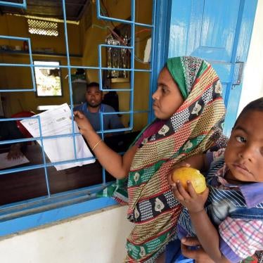 A woman carrying her son arrives to check her name on the draft list of the National Register of Citizens in Assam, India, January 2, 2018.