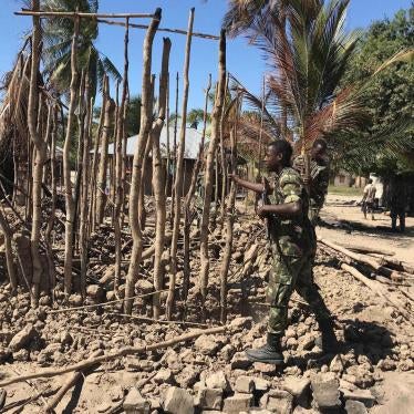 Mozambican Army soldiers bring down a structure torched by attackers to be rebuilt as shelter for people fleeing the recent attacks, in Naunde, northern Mozambique, June 13, 2018. © 2018 JOAQUIM NHAMIRRE/AFP/Getty Images