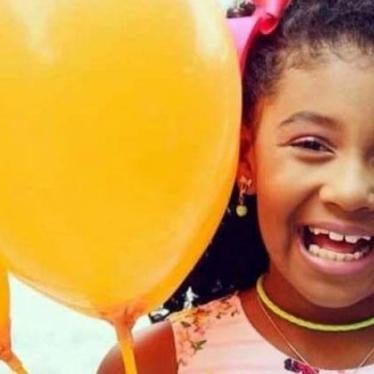 Ágatha Félix sorri para a câmera e segura balões em uma das mãos.