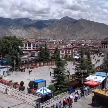People line up at a checkpoint controlling access to Barkor Square in front of the Jokhang temple in center city Lhasa.
