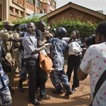 Media and members of Uganda's Human Rights Network for Journalists struggle with police as they protest outside the Daily Monitor newspaper head office