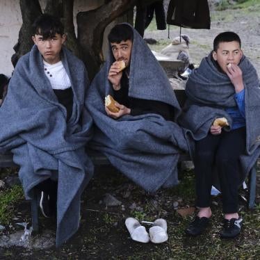 Migrants who arrived yesterday to Greece from Turkey eat bread as they try to warm themselves at the village of Skala Sikaminias, on the Greek island of Lesbos on Friday, March 6, 2020. 