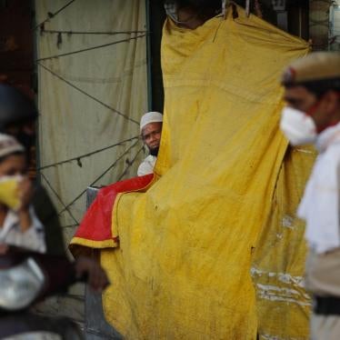 An Indian Muslim watches a policeman instructing a family riding on a scooter on social distancing on the first day of the holy month of Ramadan at the old quarters of New Delhi, India, Saturday, April 25, 2020. 